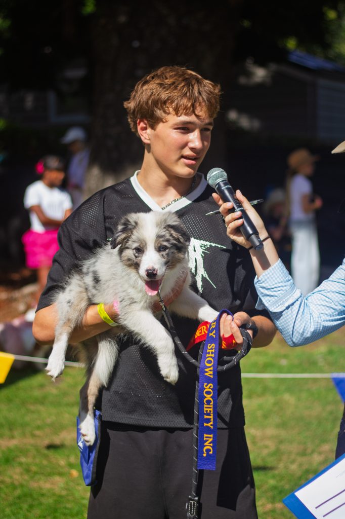 A boy talking into the microphone with his dog