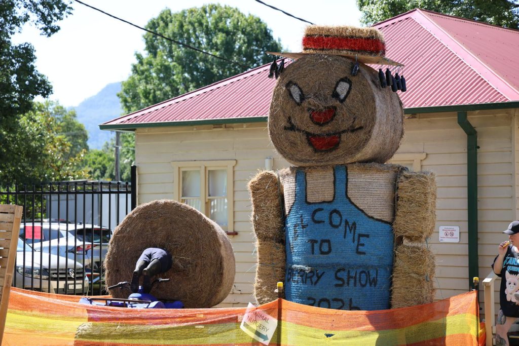 The scarecrow and a hay bale welcome sign by the gate