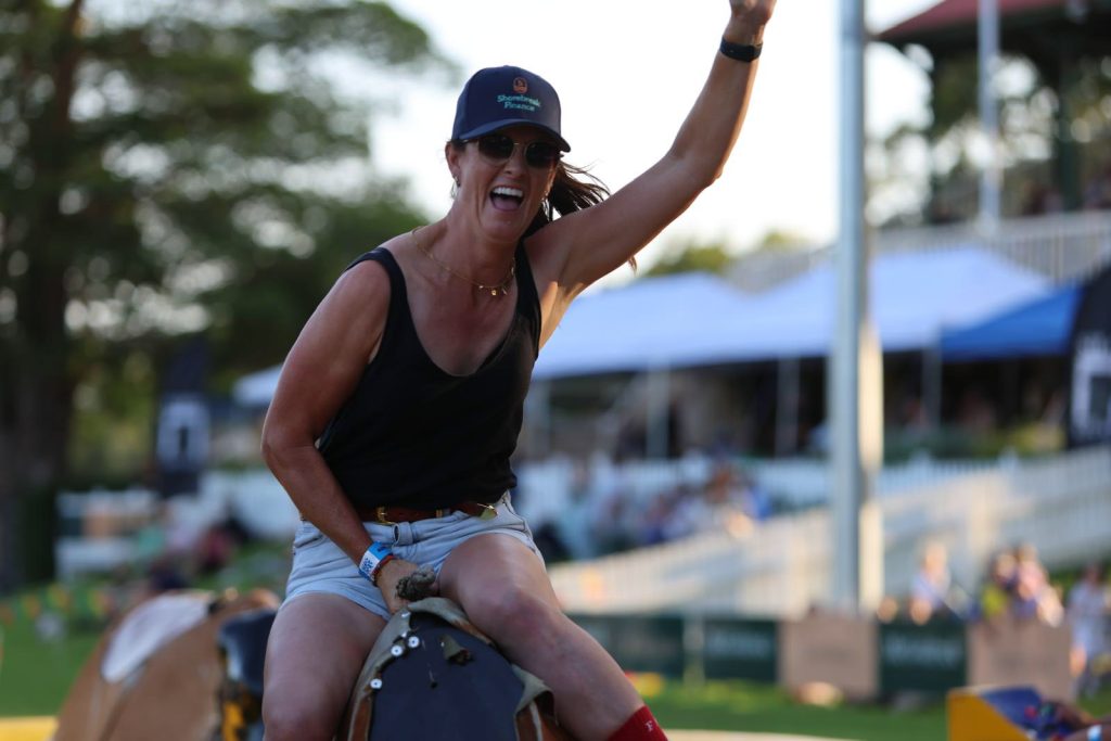 A woman holding on to the mechanical bull