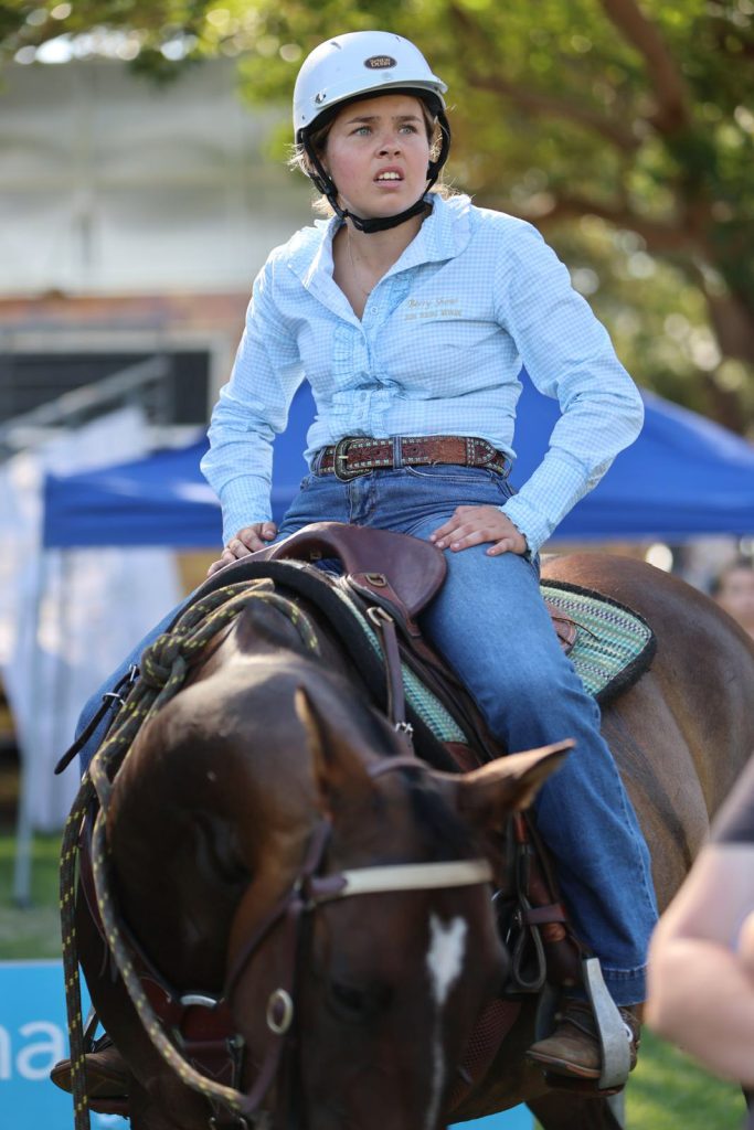 A woman in a riding helmet on horseback