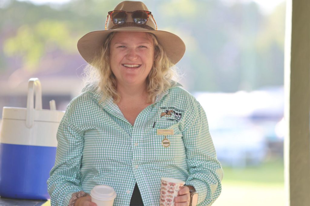 A volunteer in an Akubra holding a cup