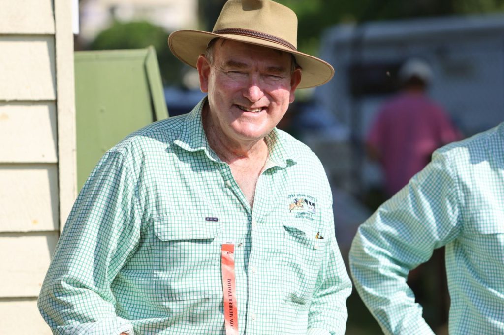 A committee member in a hat by the shed