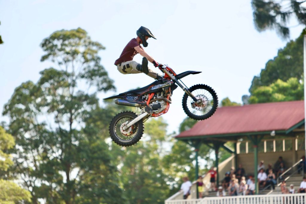 A motocross rider mid-jump against the sky