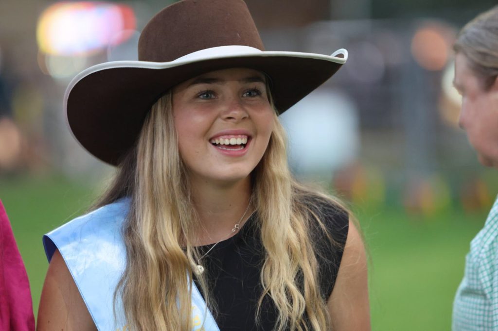 A Young Woman entrant smiling in her sash