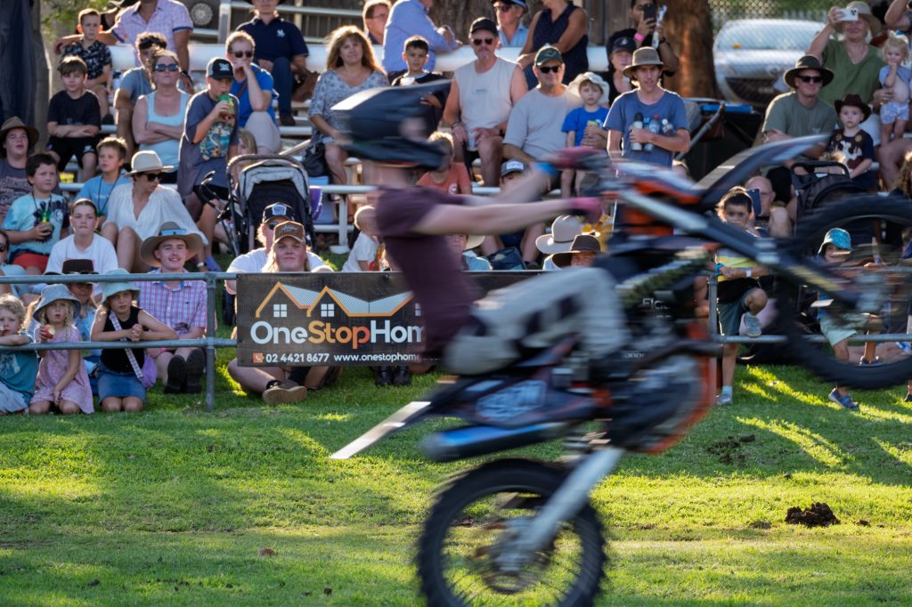 A motorbike rider in mid-air over the Main Arena crowd