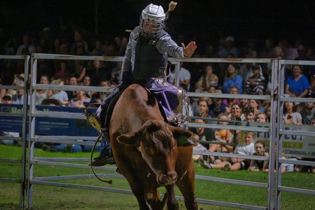 A bull rider with his arm in the air