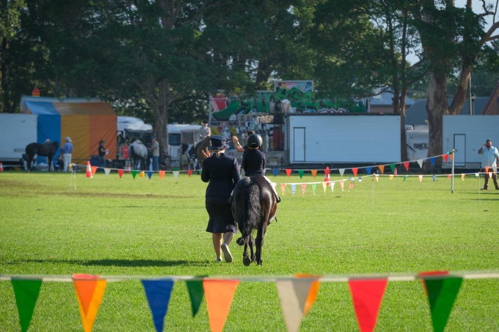 Riders working in the ring beside the bunting
