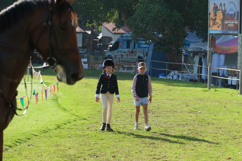 Two young riders walking out of the ring