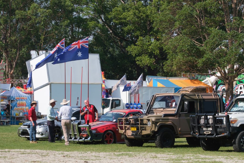 Old cars and an army truck parked in the arena
