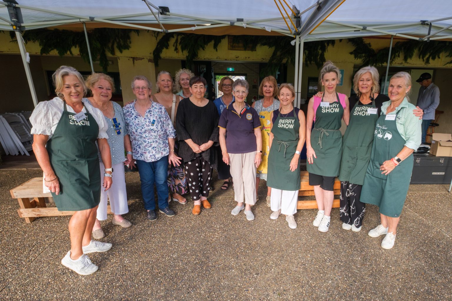A group of Berry Show volunteers, several in green Berry Show aprons