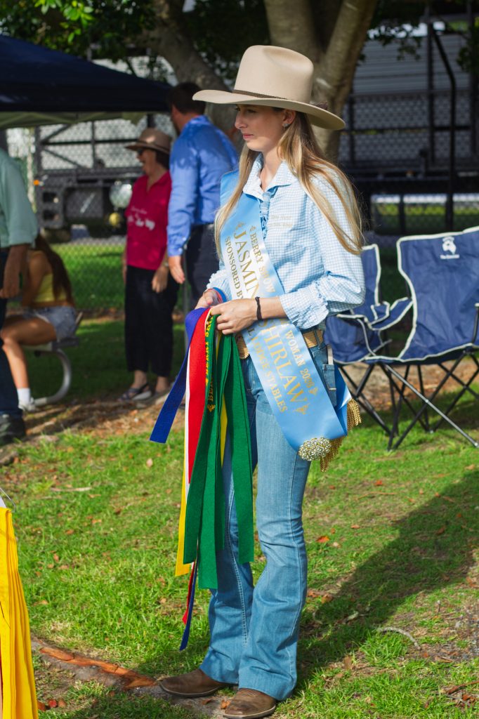 Jasmine Shirlaw in an Akubra wearing her Berry Show Young Woman sash and holding ribbons